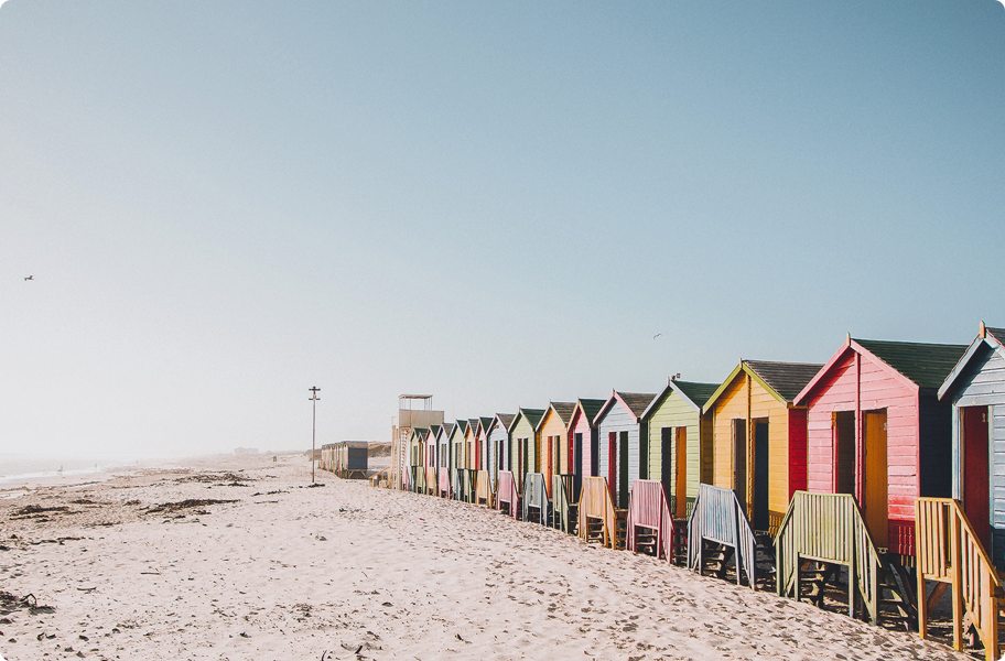 Multiple beach huts sitting on the beach